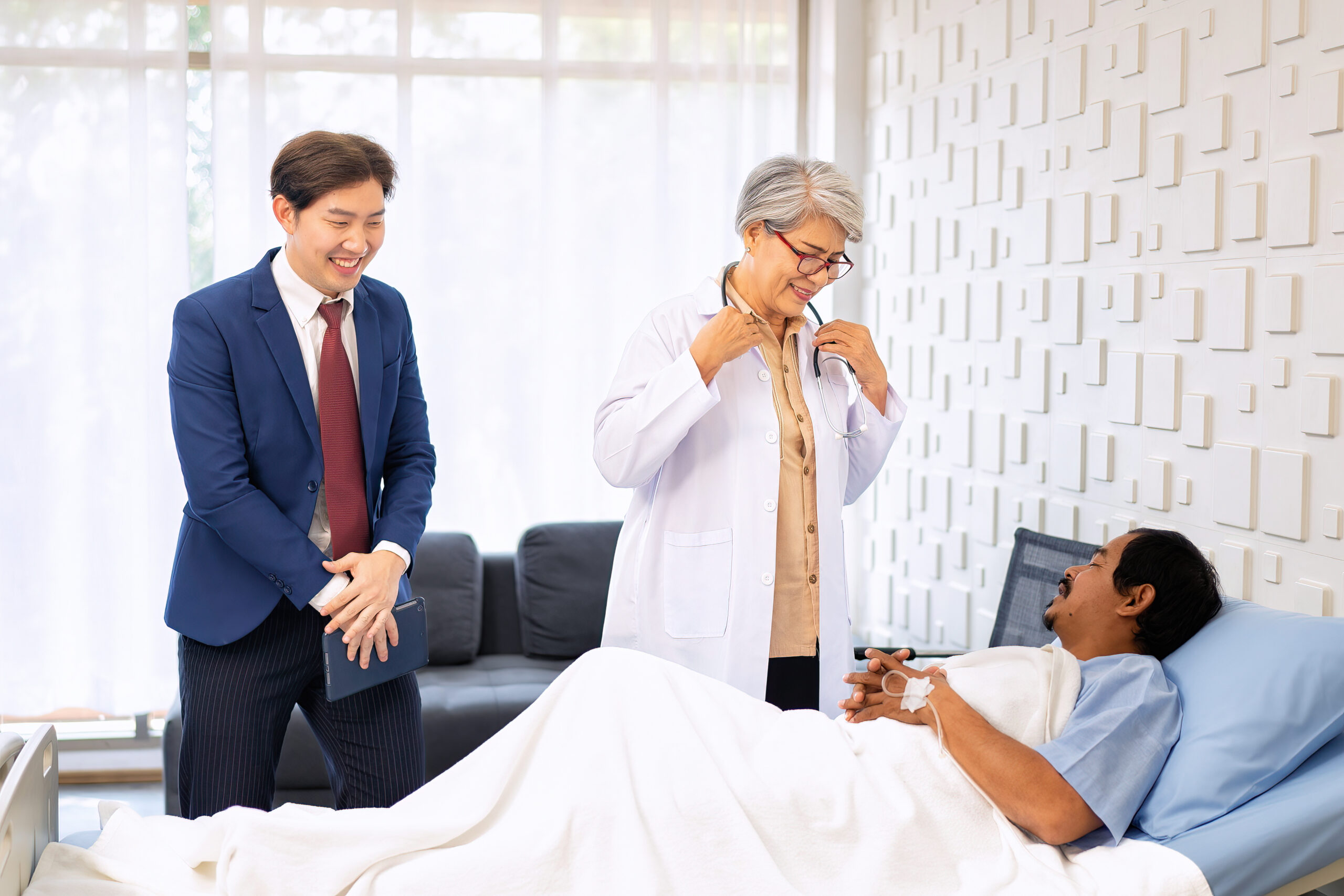 Hospital treatment room relative visit patient lay on bed doctor use stethoscope measurement - Alabama Hospice and Palliative Care Organization